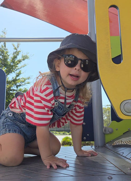 A child wearing Hey Peeps sunglasses in Matte Black